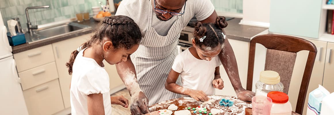 A family with kids decorating cookies in the kitchen 